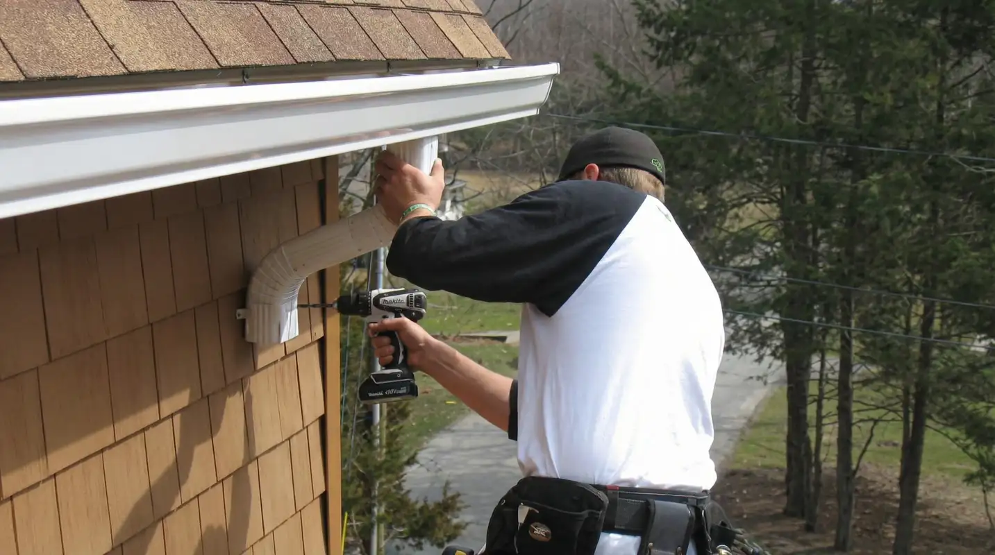 Professional contractor installing tan vinyl siding panels on a residential home exterior in Baltimore, MD